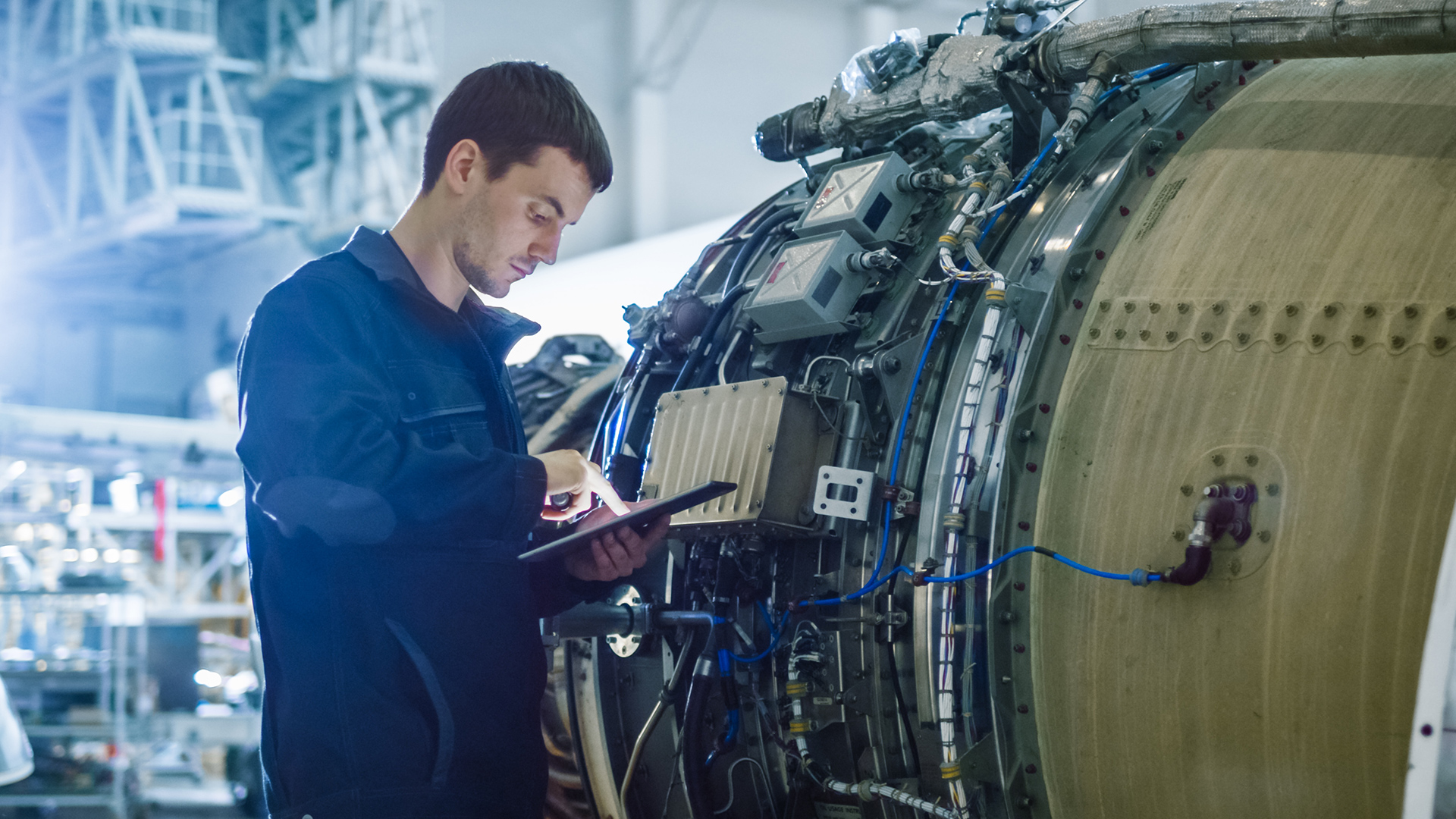 Engineer using tablet during aircraft engine inspection, reflecting how aircraft maintenance software improves MRO management, compliance tracking, and operational efficiency.