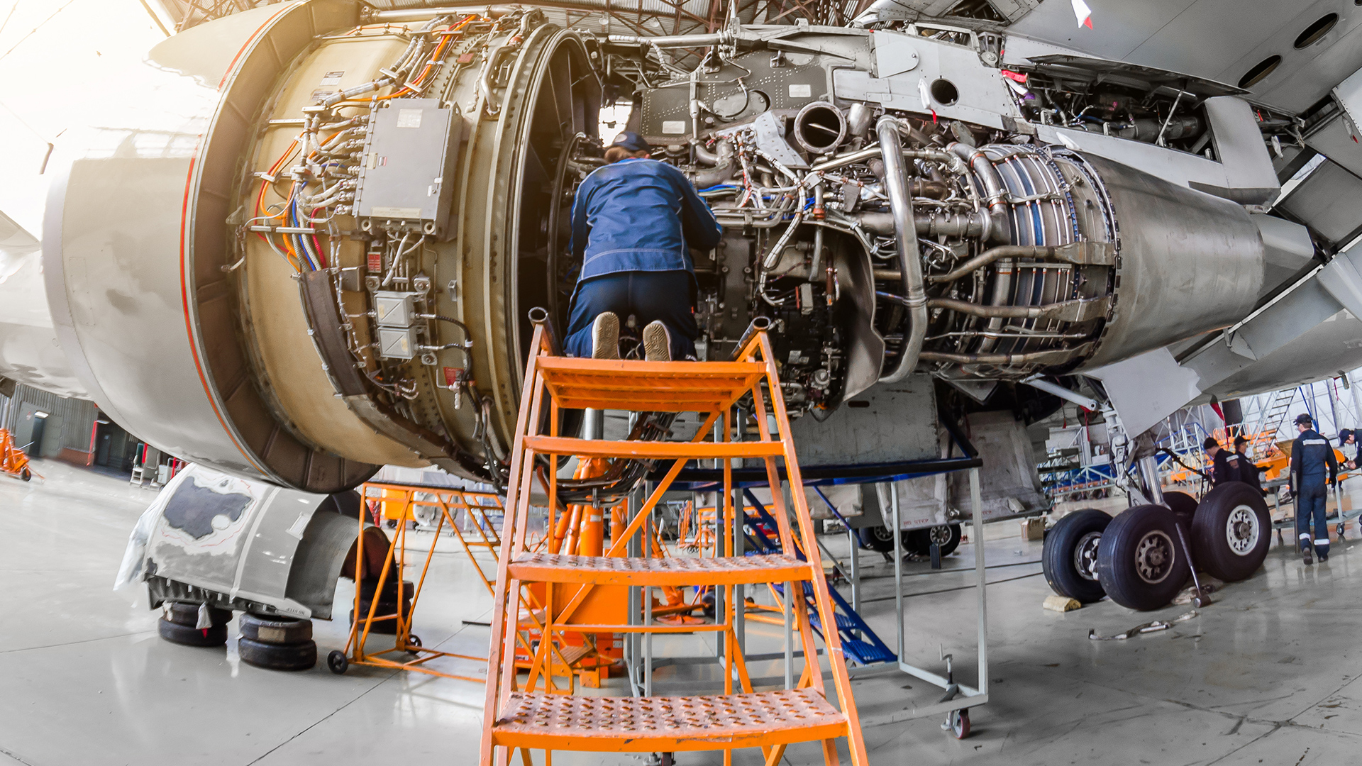 Technician conducting aircraft engine maintenance inside hangar, highlighting how aviation MRO systems support inspections, compliance, and turnaround time efficiency.